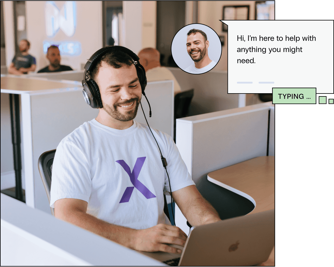 Support team member smiles looking at his computer, he types Hi I’m here to help with anything you might need in a chat